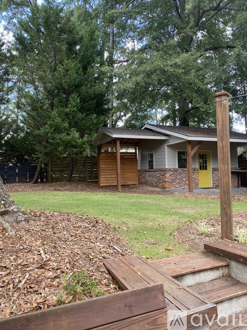 A house with a yellow door is surrounded by trees.