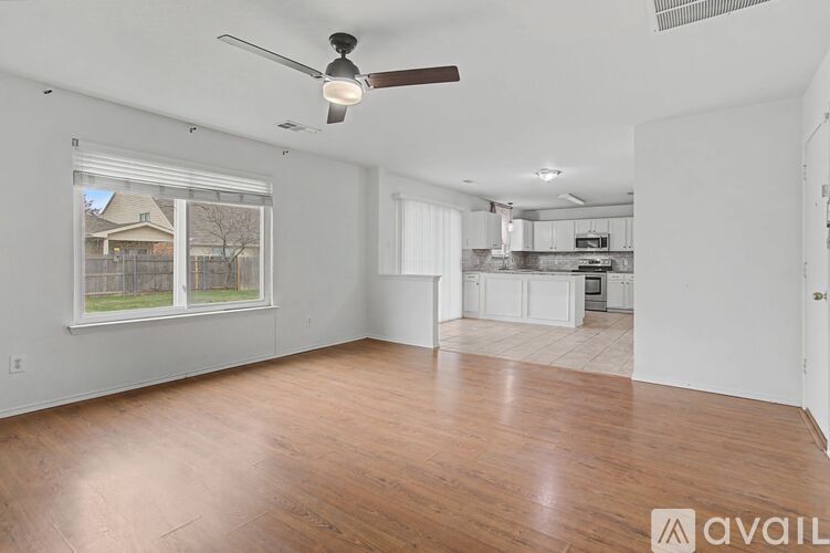 A spacious room with a ceiling fan and wooden flooring.