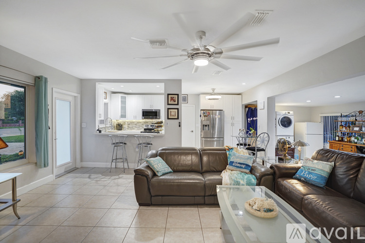 A living room with a brown couch and a ceiling fan.