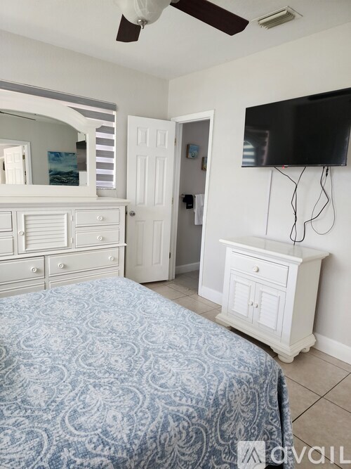 A bedroom with a bed, dresser, and television.