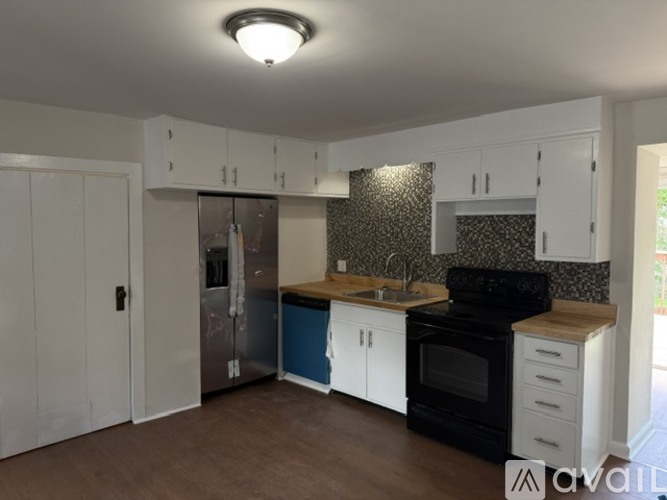 A kitchen with white cabinets and a black stove top oven.