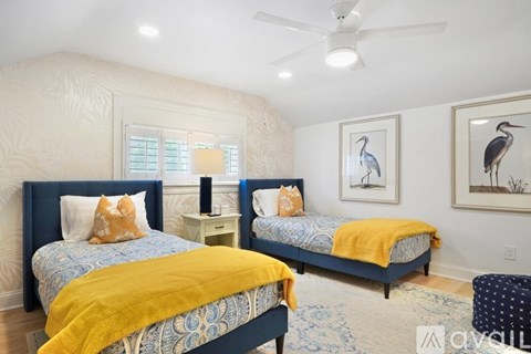 A bedroom with two beds and a ceiling fan.
