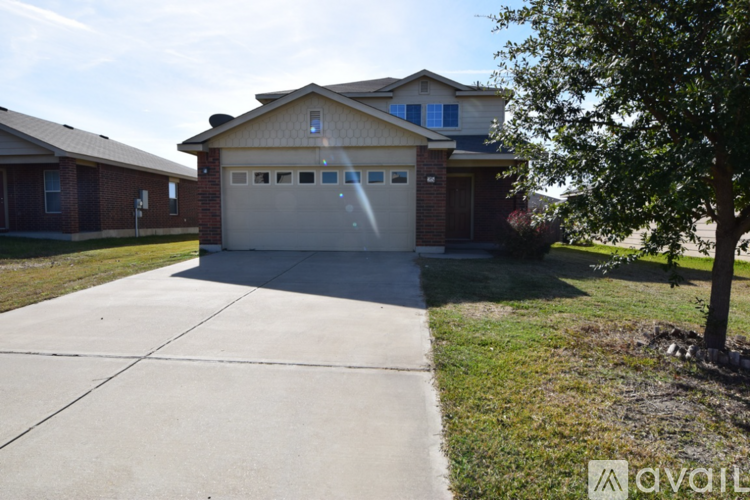 A house with a garage and a driveway in front.