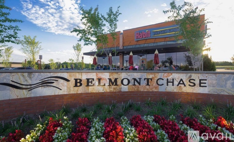 A Belmont Chase sign is displayed in front of a building with a Habitat for Humanity sign above it.