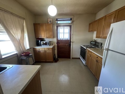 A kitchen with wooden cabinets and a white refrigerator.