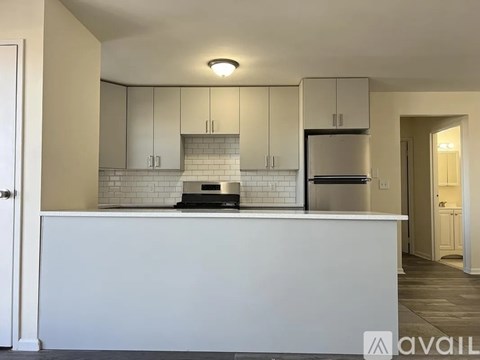 A kitchen with white cabinets and a white island.