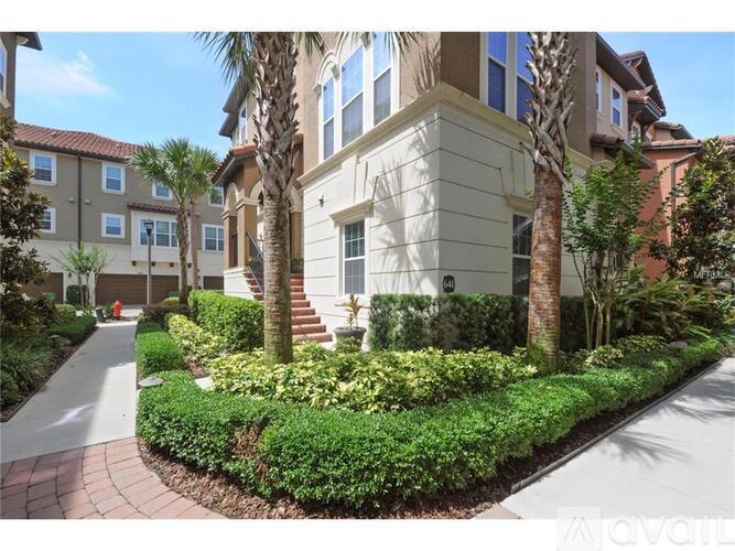 A building with a landscaped front yard and palm trees.