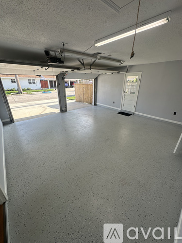 A spacious room with a grey floor and white walls.