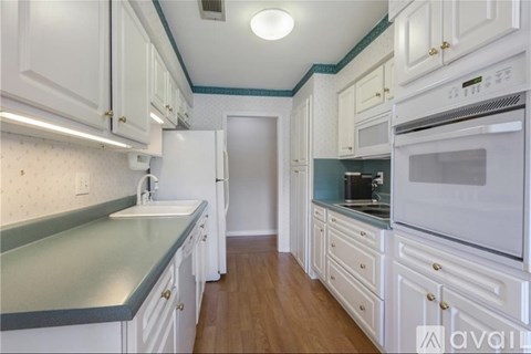 A kitchen with white cabinets and a blue counter.