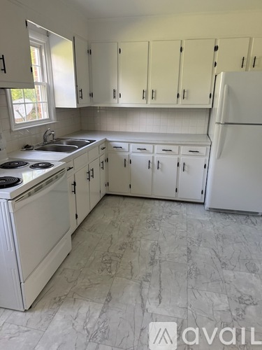 A kitchen with white appliances and cabinets.