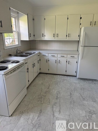 A kitchen with white appliances and cabinets.