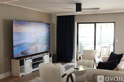 A living room with a large television and comfortable seating.