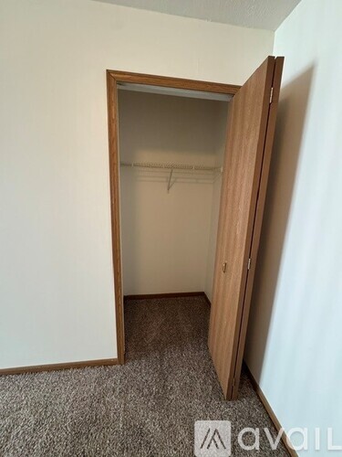 A room with a carpeted floor and a wooden door.