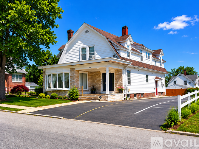 A large white house with a red door and a porch.