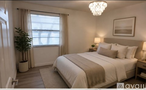 A well-lit bedroom with a large bed and a potted plant.