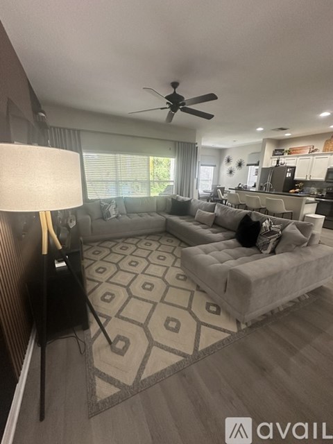 A living room with a grey couch and a black floor lamp.
