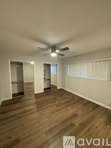 A room with wooden flooring and a ceiling fan.