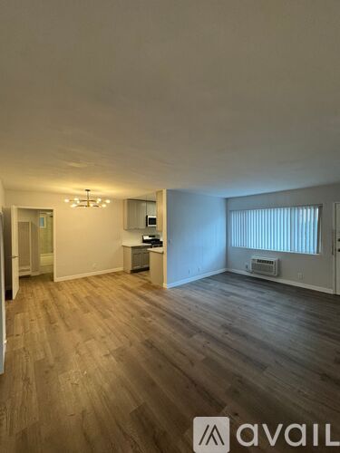 A room with wooden flooring and a chandelier.