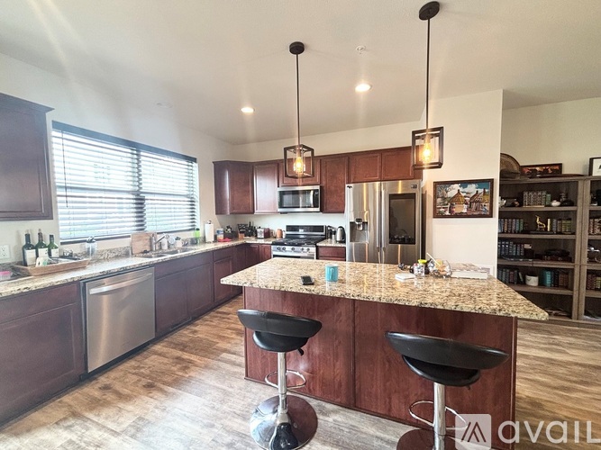 A kitchen with a bar area and two black stools.