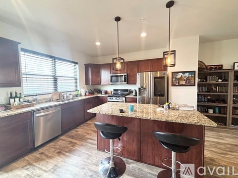 A kitchen with a bar area and two black stools.