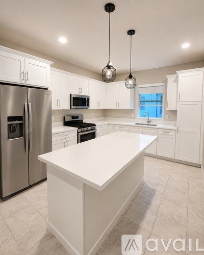 A modern kitchen with white cabinets and a large island.