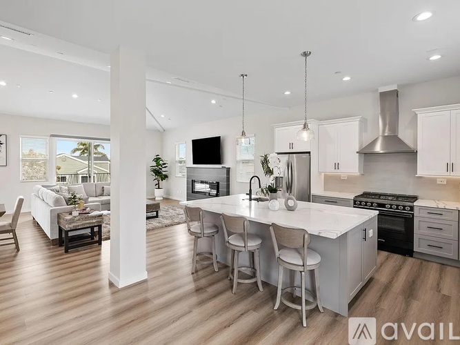 A modern kitchen with a large island and stainless steel appliances.