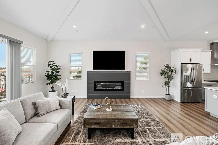 A modern living room with a grey sofa, a wooden coffee table, and a fireplace.