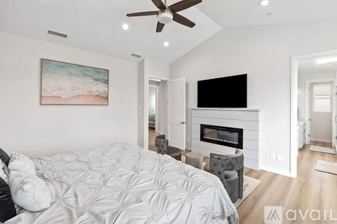 A bedroom with a large bed and a fireplace.