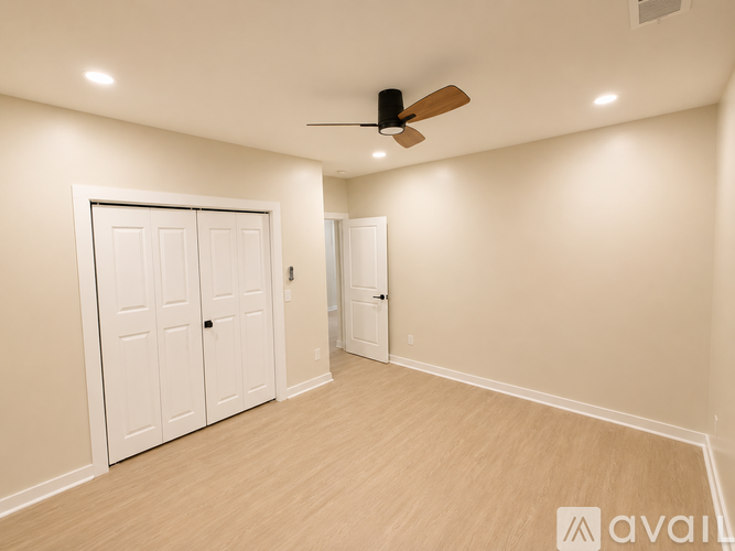 A room with a ceiling fan and two doors.
