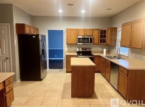 A kitchen with wooden cabinets and a black refrigerator.