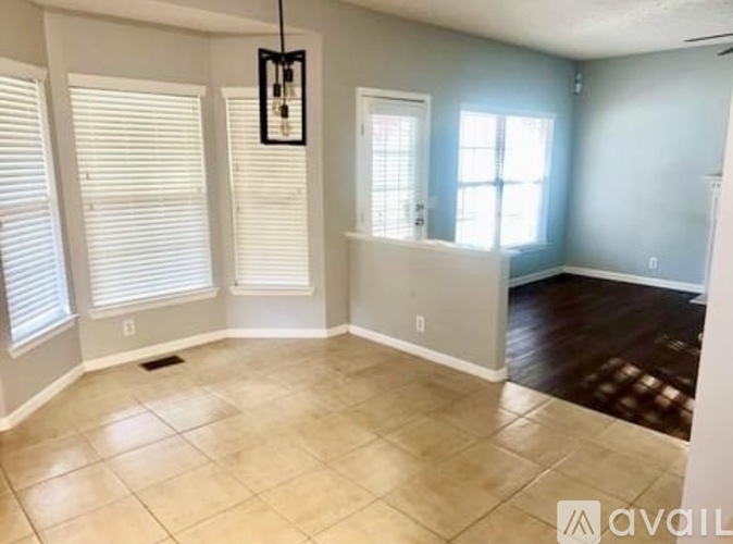 A room with a tiled floor and a window with blinds.