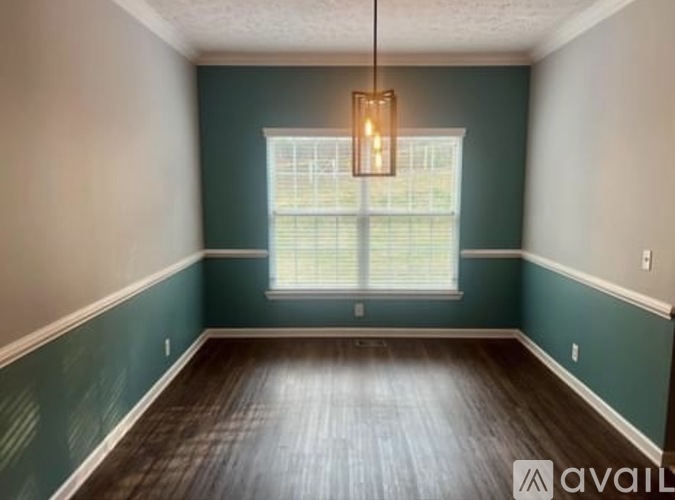 A room with a window and a hanging light fixture.
