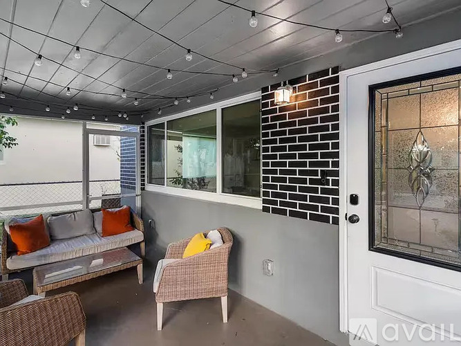 A patio with a couch, chairs, and a table.