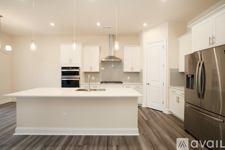 A modern kitchen with a large island and stainless steel appliances.