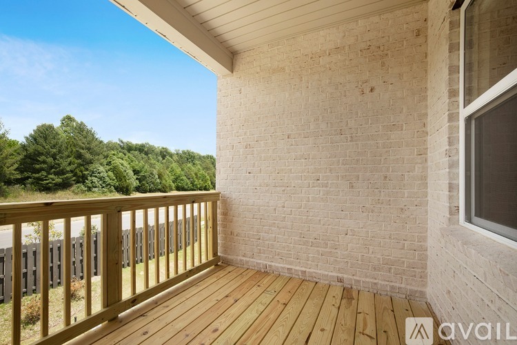 A balcony with a wooden floor and a brick wall.