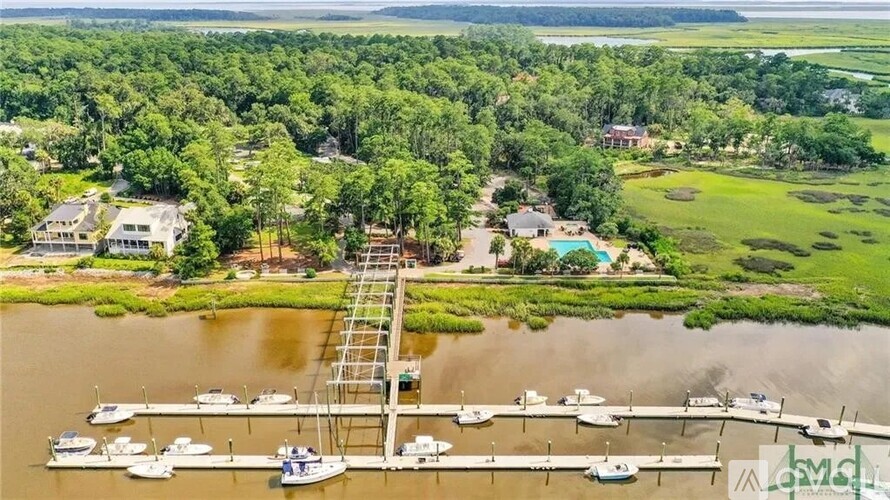 A marina with boats docked and a green landscape in the background.