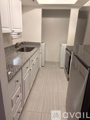 A kitchen with granite countertops and white cabinets.