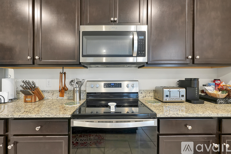 A kitchen with brown cabinets and a stove top oven.
