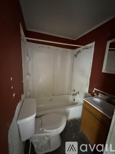 A bathroom with a toilet, sink and bathtub.