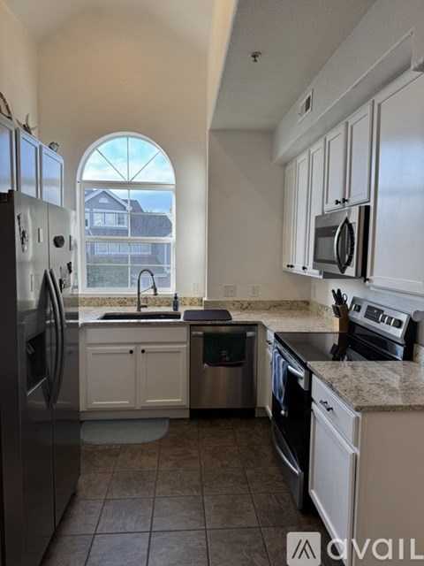 A kitchen with white cabinets and a black stove top oven.