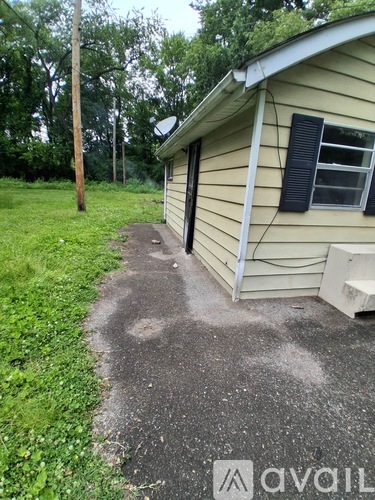 A house with a driveway and a grassy area in front.