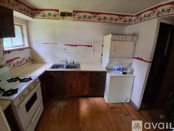 A kitchen with a stove, sink, and cabinets.