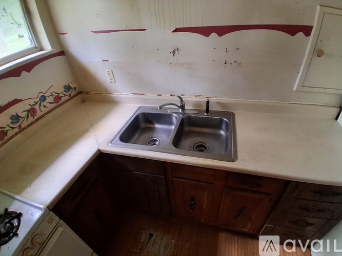 A kitchen with a double sink and a window.