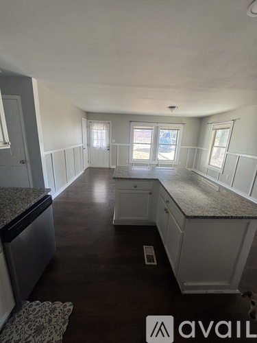 A kitchen with white cabinets and a granite countertop.