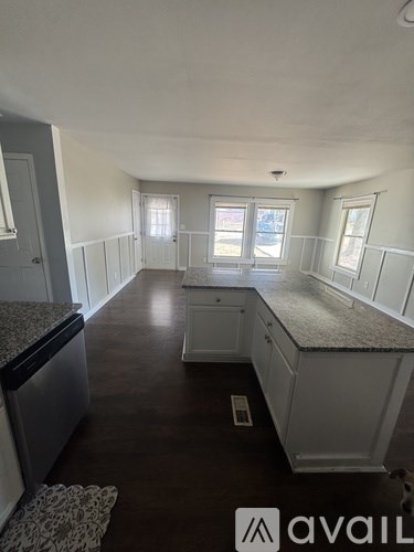 A kitchen with white cabinets and a granite countertop.
