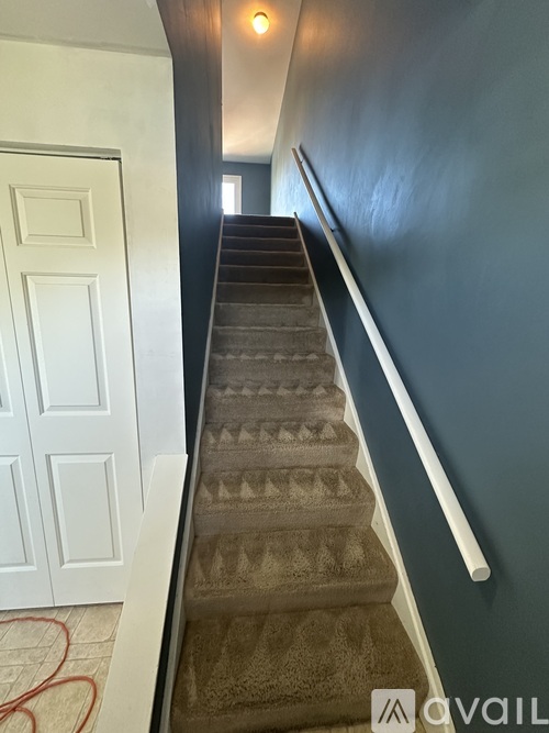 A staircase with a white railing and a white door.