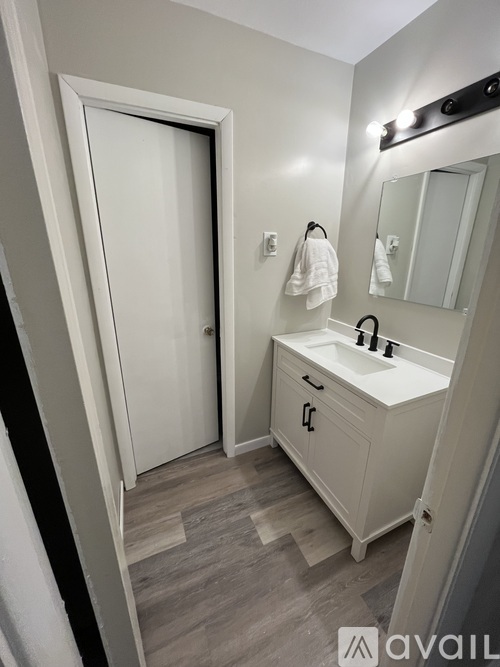 A bathroom with a white sink and a white door.