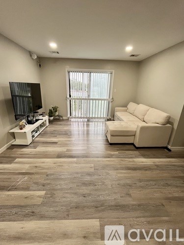 A living room with a white couch and a television.