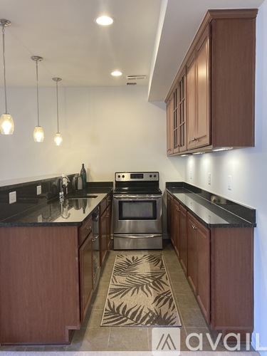 A kitchen with wooden cabinets and a black counter top.