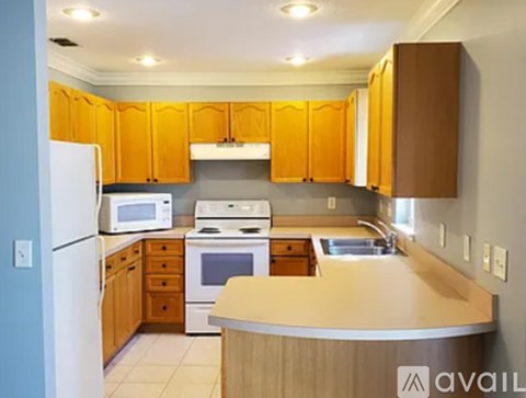 A kitchen with wooden cabinets and a white refrigerator.
